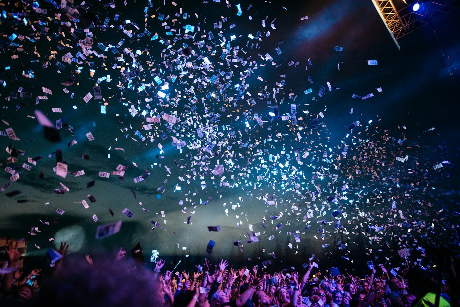 Live show with confetti and blue stage light over the crowd.